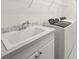 A bright laundry room features a utility sink and modern, front-load washer and dryer set for convenience at 7659 Trillium Blvd, Sarasota, FL 34241