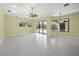 Spacious living room with tile floors, ceiling fan, and views of the pool area at 7659 Trillium Blvd, Sarasota, FL 34241
