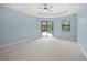 Spacious main bedroom with carpet, ceiling fan, and sliding door access to a screened-in patio and pool at 7659 Trillium Blvd, Sarasota, FL 34241
