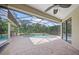 Spacious screened patio with brick floors leads to a refreshing pool and spa, blending indoor-outdoor living at 7659 Trillium Blvd, Sarasota, FL 34241