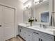 Chic bathroom with dual sinks, quartz countertop, decorative mirrors, and wood-look tile flooring at 8123 Wawana Rd, North Port, FL 34287