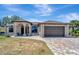 Charming single-story home with a brick driveway, arched entrance, and a two-car garage at 8123 Wawana Rd, North Port, FL 34287