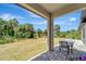 The covered patio offers a serene view of the lush backyard and a charming stone paver patio at 8123 Wawana Rd, North Port, FL 34287