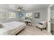 Cozy bedroom with a ceiling fan, a television, and a comfortable reading chair at 8420 43Rd Avenue W Dr, Bradenton, FL 34209