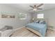 Comfortable bedroom with a ceiling fan, light gray walls, and beach-themed artwork at 8420 43Rd Avenue W Dr, Bradenton, FL 34209