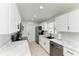 Bright kitchen features white cabinets, black appliances, and marble countertops with a view from the window at 8420 43Rd Avenue W Dr, Bradenton, FL 34209
