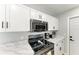 Close up of the kitchen featuring stainless steel microwave, black stove and coffee maker on a marble countertop at 8420 43Rd Avenue W Dr, Bradenton, FL 34209