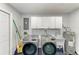 Modern laundry room with Samsung washer/dryer and overhead white storage cabinets at 8420 43Rd Avenue W Dr, Bradenton, FL 34209
