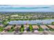 Wide aerial view of a home with manicured lawns, set within a community featuring a lake and golf course at 8603 River Preserve Dr, Bradenton, FL 34212