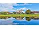 Picturesque backyard view reflects a tranquil pond and well-maintained property featuring a screened in pool at 8603 River Preserve Dr, Bradenton, FL 34212