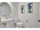Bright half bathroom featuring a pedestal sink, nautical decor, and a convenient toilet at 8603 River Preserve Dr, Bradenton, FL 34212