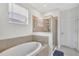 Elegant bathroom featuring a soaking tub, a glass-enclosed shower, and modern fixtures at 8603 River Preserve Dr, Bradenton, FL 34212