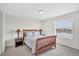 Cozy bedroom with a wooden bed frame, soft gray bedding, and a bright window with a peaceful view at 8603 River Preserve Dr, Bradenton, FL 34212