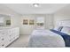 Relaxing bedroom featuring a full size bed, white dresser, serene decor and bright natural light at 8603 River Preserve Dr, Bradenton, FL 34212