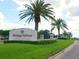 Community entrance sign on a sunny day featuring lush green grass and palm trees at 8603 River Preserve Dr, Bradenton, FL 34212