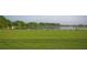 Scenic view of golfers practicing on the green golf course by the lake surrounded by lush greenery and mature trees at 8603 River Preserve Dr, Bradenton, FL 34212