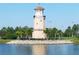 Beautiful lighthouse with black railing and palm trees near the water on a sunny day at 8603 River Preserve Dr, Bradenton, FL 34212