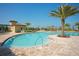 Beautiful pool area with clear blue water, palm trees, lounge chairs and lush landscaping for relaxation at 8603 River Preserve Dr, Bradenton, FL 34212