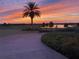 Stunning sunset view overlooking the lush landscape and the nearby water feature, showcasing the beautiful community at 8603 River Preserve Dr, Bradenton, FL 34212