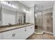 Bright bathroom featuring double sinks, granite countertops, and a glass-enclosed shower with tile accents at 927 River Basin Ct # 201C, Bradenton, FL 34212