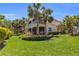 Exterior of property with multiple screened-in balconies and a meticulously maintained lawn and tropical landscaping at 927 River Basin Ct # 201C, Bradenton, FL 34212