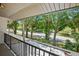 Open-air balcony with metal railing, offering peaceful views of the green landscape at 928 Sunridge Dr # F2, Sarasota, FL 34234