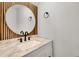Chic powder room featuring a marble vanity top and unique wood-slat accent wall at 928 Sunridge Dr # F2, Sarasota, FL 34234