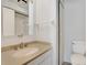 Well-lit bathroom featuring a vanity with solid surface top, toilet, and shower at 928 Sunridge Dr # F2, Sarasota, FL 34234