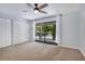 Bright bedroom boasts a ceiling fan, balcony access, neutral carpet, and ample closet space at 928 Sunridge Dr # F2, Sarasota, FL 34234