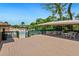 Exterior community deck providing a shady space with tables and chairs, overlooking the sparkling community pool at 928 Sunridge Dr # F2, Sarasota, FL 34234