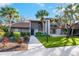 Charming home exterior featuring lush landscaping, mature palm trees, and a well-maintained lawn at 928 Sunridge Dr # F2, Sarasota, FL 34234