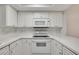 Modern white kitchen with white appliances, subway tile backsplash, and bright lighting at 928 Sunridge Dr # F2, Sarasota, FL 34234