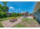 This home's backyard features a fire pit, luscious landscaping, and covered patio at 9321 New Martinsville Ave, Englewood, FL 34224