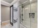 Bathroom with glass enclosed tub and shower, as well as linen closet, and white tile floors at 9321 New Martinsville Ave, Englewood, FL 34224