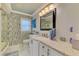 This bathroom features a decorative wall, large countertop, and modern light fixture, with white cabinets at 9321 New Martinsville Ave, Englewood, FL 34224