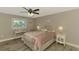 Bedroom features gray hardwood floors, ceiling fan, two side tables and a desk at 9321 New Martinsville Ave, Englewood, FL 34224