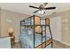 This bedroom features a bunk bed with metal frame and ceiling fan, with beautiful gray wood look floors at 9321 New Martinsville Ave, Englewood, FL 34224