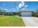 Desirable single-Gathering home with lush landscaping, mature trees, and a large driveway leading to an attached two-car garage at 9321 New Martinsville Ave, Englewood, FL 34224