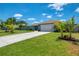 Beautiful home featuring meticulous landscaping, lovely palms, and an extended drive leading to an attached two-car garage at 9321 New Martinsville Ave, Englewood, FL 34224
