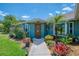 Charming home featuring an inviting front entryway with mature trees and plants, a walkway, and natural lighting at 9321 New Martinsville Ave, Englewood, FL 34224