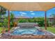 Backyard hot tub with a canopy, offering a relaxing outdoor experience surrounded by greenery at 9321 New Martinsville Ave, Englewood, FL 34224
