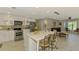 Open concept kitchen with white cabinets, marble island, and stainless steel appliances at 9321 New Martinsville Ave, Englewood, FL 34224