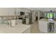 Bright kitchen features white cabinets, stainless steel appliances, and a marble countertop island at 9321 New Martinsville Ave, Englewood, FL 34224