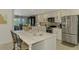 Modern kitchen with white cabinets, a stainless steel refrigerator, and a marble island at 9321 New Martinsville Ave, Englewood, FL 34224