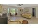 Bright living room featuring an ornate sofa, a bay window, and light wood flooring at 9321 New Martinsville Ave, Englewood, FL 34224