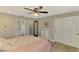 This main bedroom offers gray hardwood floors, ceiling fan, closet and en suite bathroom at 9321 New Martinsville Ave, Englewood, FL 34224