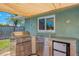 Outdoor kitchen with stainless steel appliances, including a grill, sink, and refrigerator at 9321 New Martinsville Ave, Englewood, FL 34224