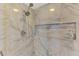 Modern shower with marble tile, shower niche, and a dual shower head at 9321 New Martinsville Ave, Englewood, FL 34224