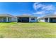 Wide backyard with lush green lawn showcasing the home's exterior and covered patio at 1007 Waterline Ct, Sarasota, FL 34240
