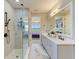 Modern bathroom with double sinks, quartz countertops, frameless glass shower, and views into the Primary bedroom at 1007 Waterline Ct, Sarasota, FL 34240